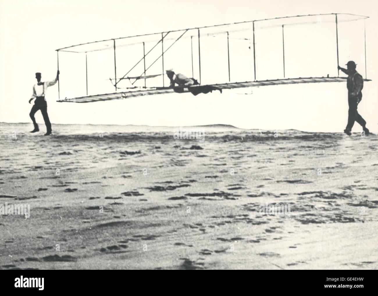 Dieses historische Foto, aufgenommen am 10. Oktober 1902, zeigt Wilbur Wright an der Steuerung ihres dritten Testgleiters in Kill Devil Hills, North Carolina. Der 1902er-Schirm der Brüder Wright zeigte Verbesserungen aus Windkanaltests, einschließlich eines neuen Ruders für bessere Kontrolle. Stockfoto Dieses historische Foto, aufgenommen am 10. Oktober 1902, zeigt Wilbur Wright an der Steuerung ihres dritten Testgleiters in Kill Devil Hills, North Carolina. Der 1902er-Schirm der Brüder Wright zeigte Verbesserungen aus Windkanaltests, einschließlich eines neuen Ruders für bessere Kontrolle. Stockfoto