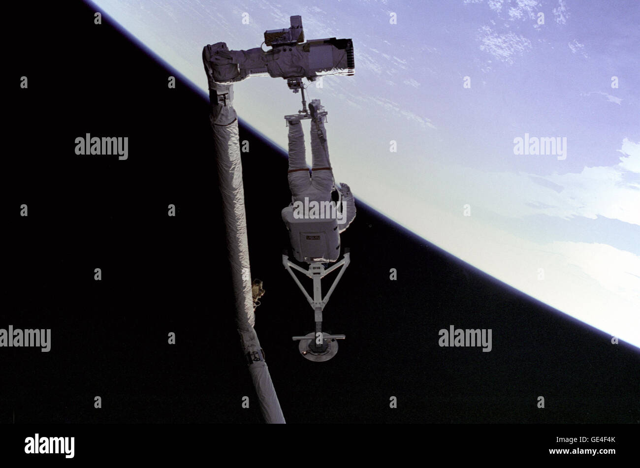 STS-49 Mission Spezialist Pierre Thuot thront auf der Endeffektor des Roboterarms (Remote Manipulator System/RMS), mit Intelsat VI Capture Bar. Dies wäre einer der vielen Versuche, "Greifer" der Intelsat VI-Satellit der unwirksam gemacht wurde, als seine Payload Assist Module (PAM) Motor nicht Feuer erreichen einer operativen Höhe verhindert.  Bild #: S49-214-028 Datum: 13. Mai 1992 Stockfoto