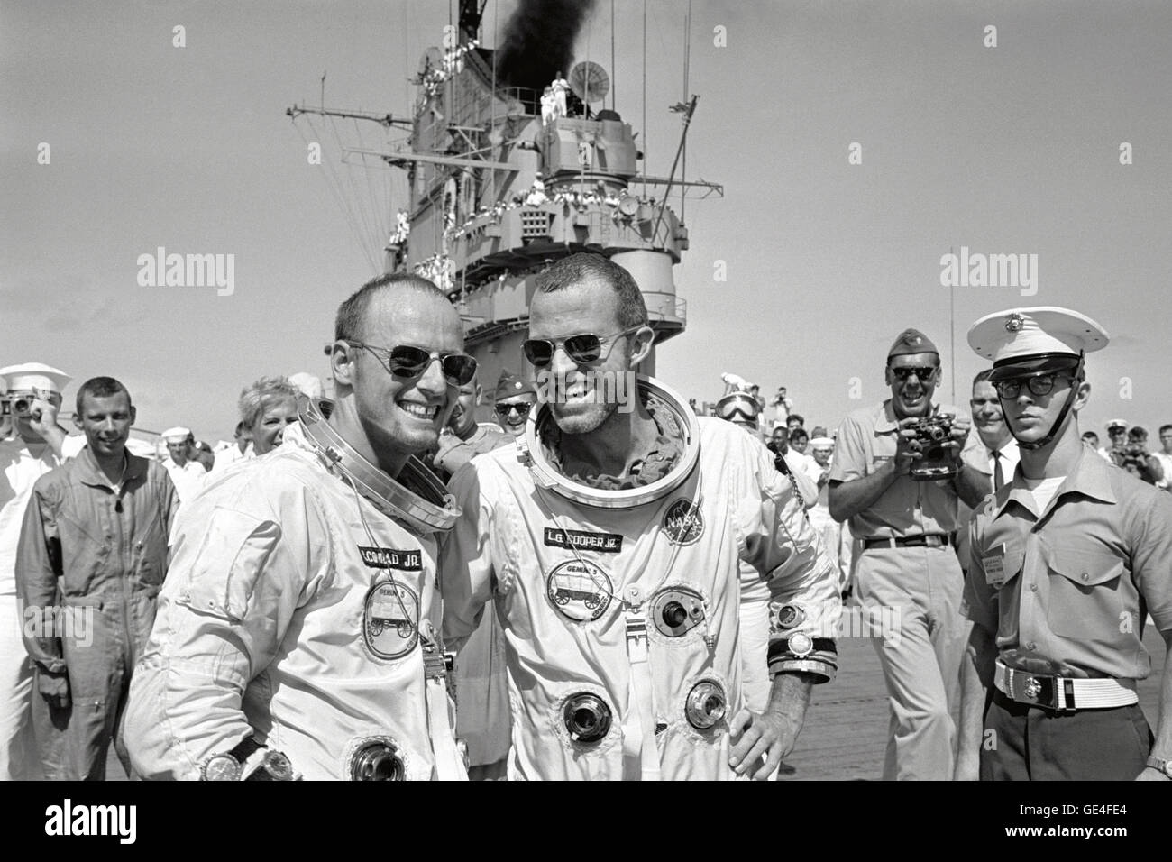 Die Astronauten Gordon Cooper und Charles Conrad gehen über das Deck der USS Lake Champlain, nachdem sie sich von der Gemini 5-Mission erholten, die damals der längste bemannte Raumflug war. Stockfoto