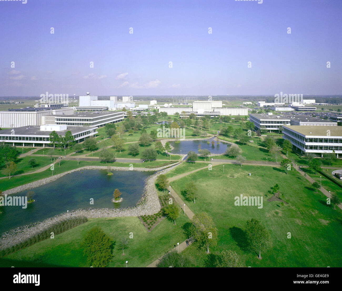 Diese Nord-Suche Ansicht zeigt einige der am Johnson Space Center zentrale Gebäude und Einrichtungen, die benachbarten seine Project Management Facility (Gebäude 1) aus, die diese Szene fotografiert wurde. Das Houston ansässige Mission Control Center ist in der Mitte des Rahmens. Sichtbare Gebäude rund um den Mallbereich gehören Flight Operations Facility, Crew Systems Laboratory, fotografische Technology Laboratory, technischen Service Shop, Filiale Cafeteria, Mission Control Center Bürotrakt und die zentrale Daten.  Bild-Nr.: S82-41180 Stockfoto