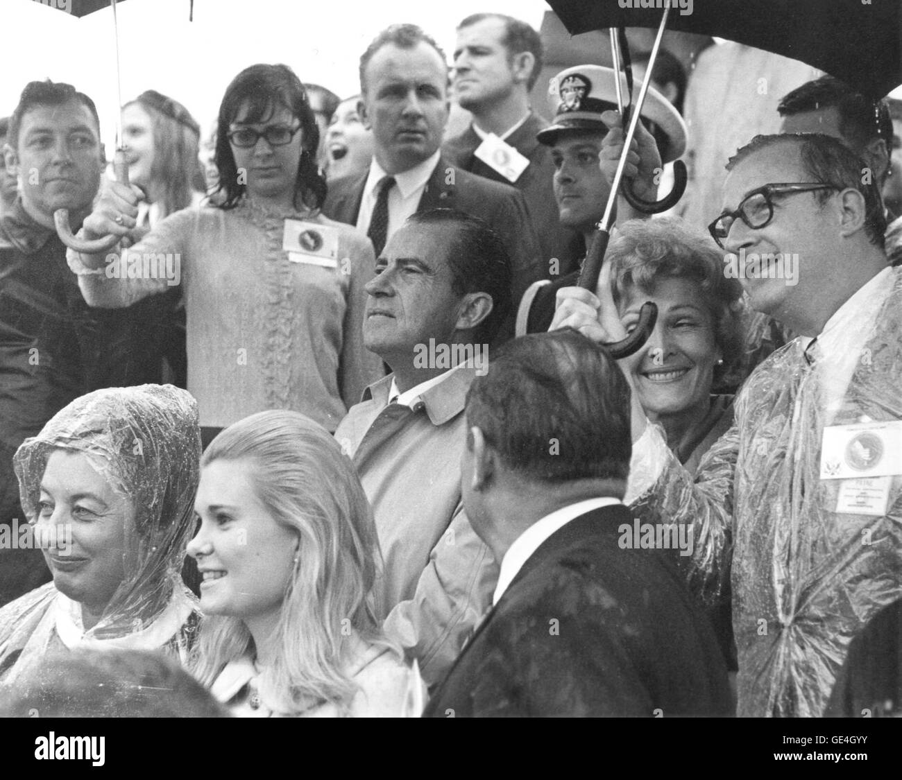 NASA-Administrator Dr. Thomas Paine schützt First Lady Mrs. Nixon vor Regen, während Präsident Nixon Apollo 12-Aktivitäten im Kennedy Space Center beobachtet. Der Präsident gratulierte später der Startmannschaft. Stockfoto