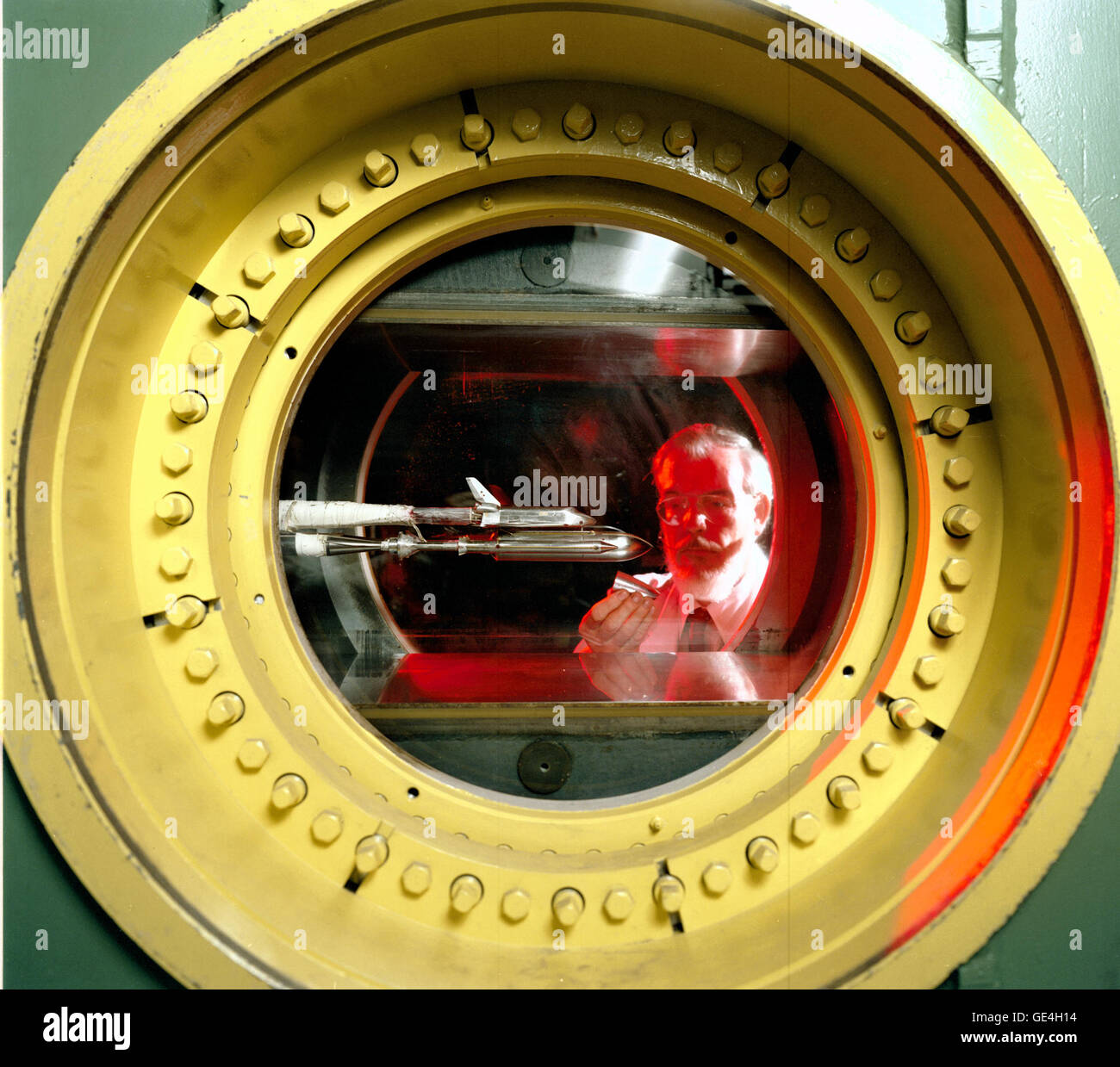 Ein Ingenieur des Marshall Space Flight Centers besitzt ein Modell des Liquid Booster Moduls, während er Tests im 14 Windtunnel beobachtet, der für die Prüfung von Raketen und Raumfahrzeugen unter Unterschall-, Transsonal- und Überschallbedingungen verwendet wird. Stockfoto