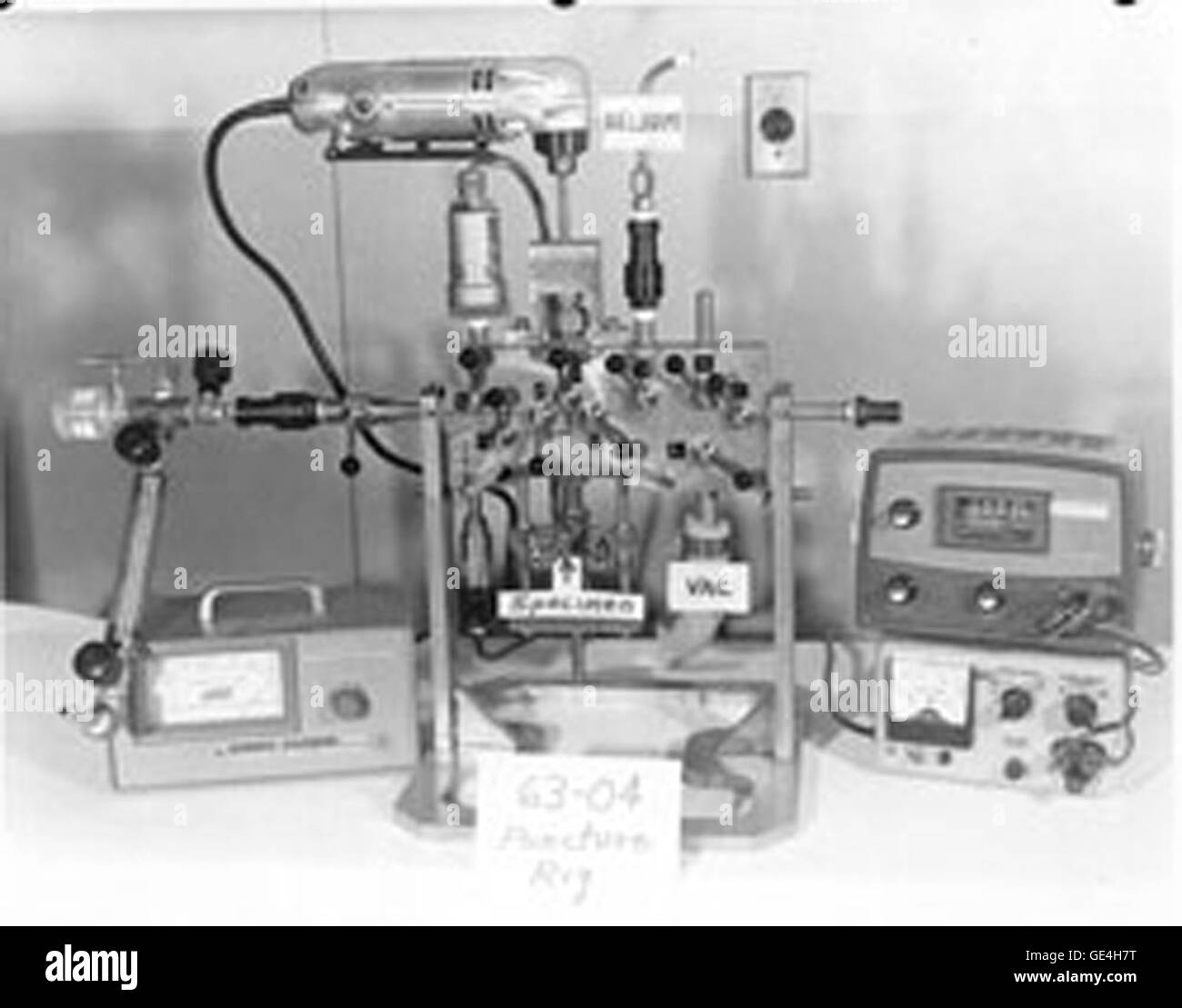Rig zu durchbohren. Punktion-Rigs wurden verwendet, um die Außenkapsel jedes Experiment zu durchdringen und messen die Druckerhöhung in der Anlage durch freigesetzten Gase während der Bestrahlung. Kunststoff Flasche auf der linken Seite wurde verwendet, um das Isotop Inhalt der Kernspaltung Produkt Gase, Xenon und Krypton, mit Gamma Ray-Spektrometrie bestimmen; Die röhrenförmigen Probenbehälter unten, den es verwendet wurde, um die Volumenprozent der beiden Gase zu messen. Die gesamte Punktion Betrieb und Sammlung von Gasproben erfolgte in den heißen Zellen mithilfe der Fernbedienungen Manipulatoren. Die Probenbehälter wurden dann von der Punktion entfernt ri Stockfoto