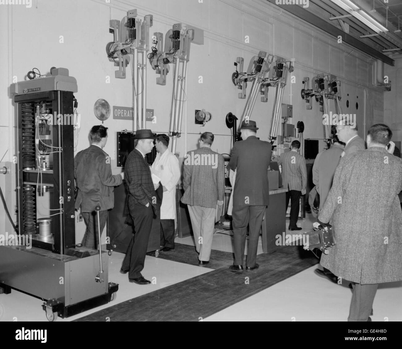 Ein Foto von Reportern im Glenn Research Center der NASA im Jahr 1961, die durch das heiße Labor gingen, das für Hochtemperaturtests von Materialien verwendet wird. Das Bild zeigt das Interesse der Presse an der Raumfahrtforschung der NASA in den ersten Jahren des Weltraumrennens. Stockfoto