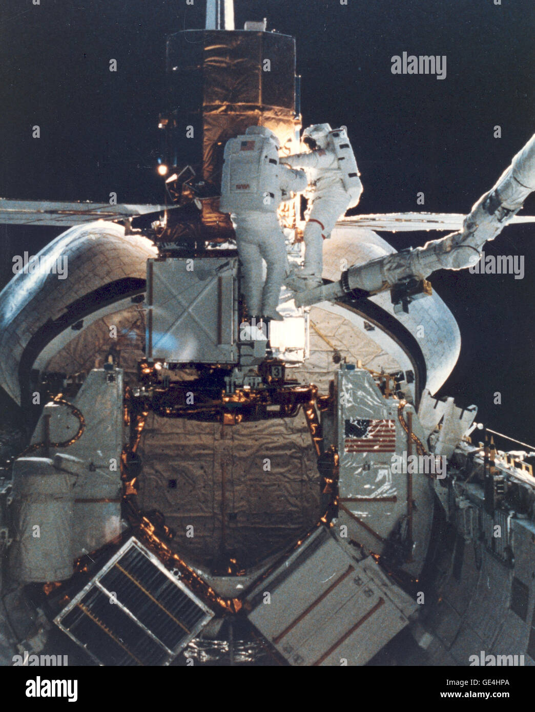 STS - 41C Astronauten George D. Nelson, rechts, und James D. van Hoften teilen eine Reparatur Aufgabe bei den erfassten Solar maximale Mission Satelliten (SMMS) im hinteren Ende der Herausforderer Laderaum. Die beiden Missionsspezialisten verwenden Sie mobile Fuß Zurückhaltung und das remote Manipulator System (RMS) als "Cherry-Picker" Gerät für umhergehen. Später hob der RMS einmal mehr die SMMS in den Weltraum.  Bild-Nr.: 84-H-168 Datum: 11. April 1984 Stockfoto