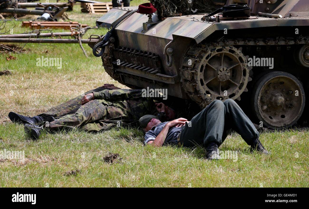 Mitglieder einer militärischen Reenactment-Gruppe etwas Schatten unter einem Tank wie Krieg und Frieden-Revival in der Nähe von Folkestone, Kent weiter zu finden. Stockfoto