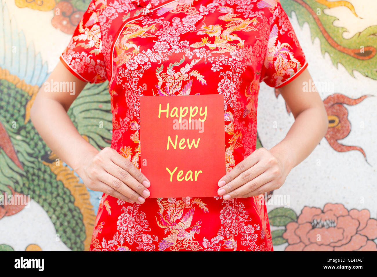 Frohes neues Jahr Asiatin mit roten Cheongsam hält ein rotes Paket wünschen Ihnen frohes neues Jahr auf chinesische Muster traditi Stockfoto