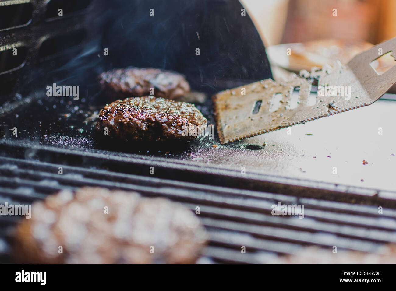 Heißes frisches Rindfleisch Hamburger auf Grill und Brot Stockfoto