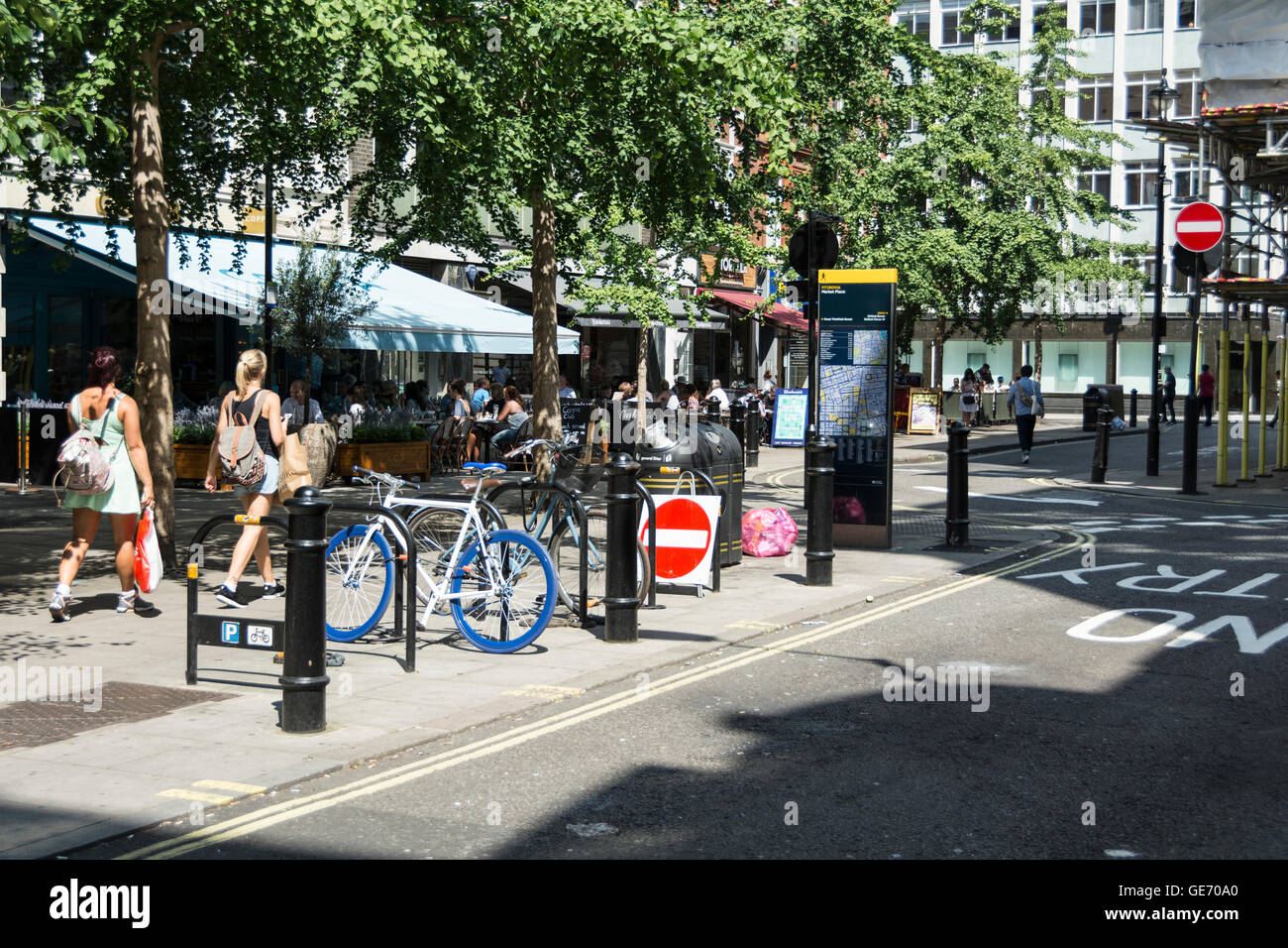 Käufer zu Fuß entlang einer ruhigen Seitenstraße von London in der Nähe Marktplatz, off Oxford Street. Stockfoto