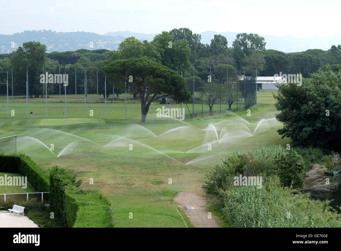 Ein ausgeklügeltes Sprinkler System Gewässer ein Golfplatz fairway Stockfoto
