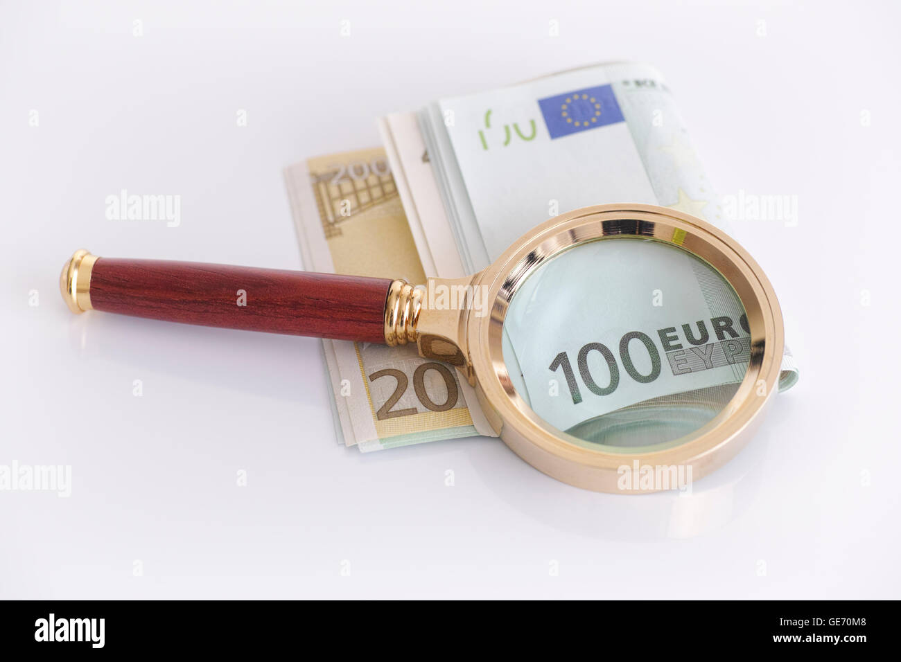 Lupe und Euro-Banknoten. Krisenkonzept. Stockfoto