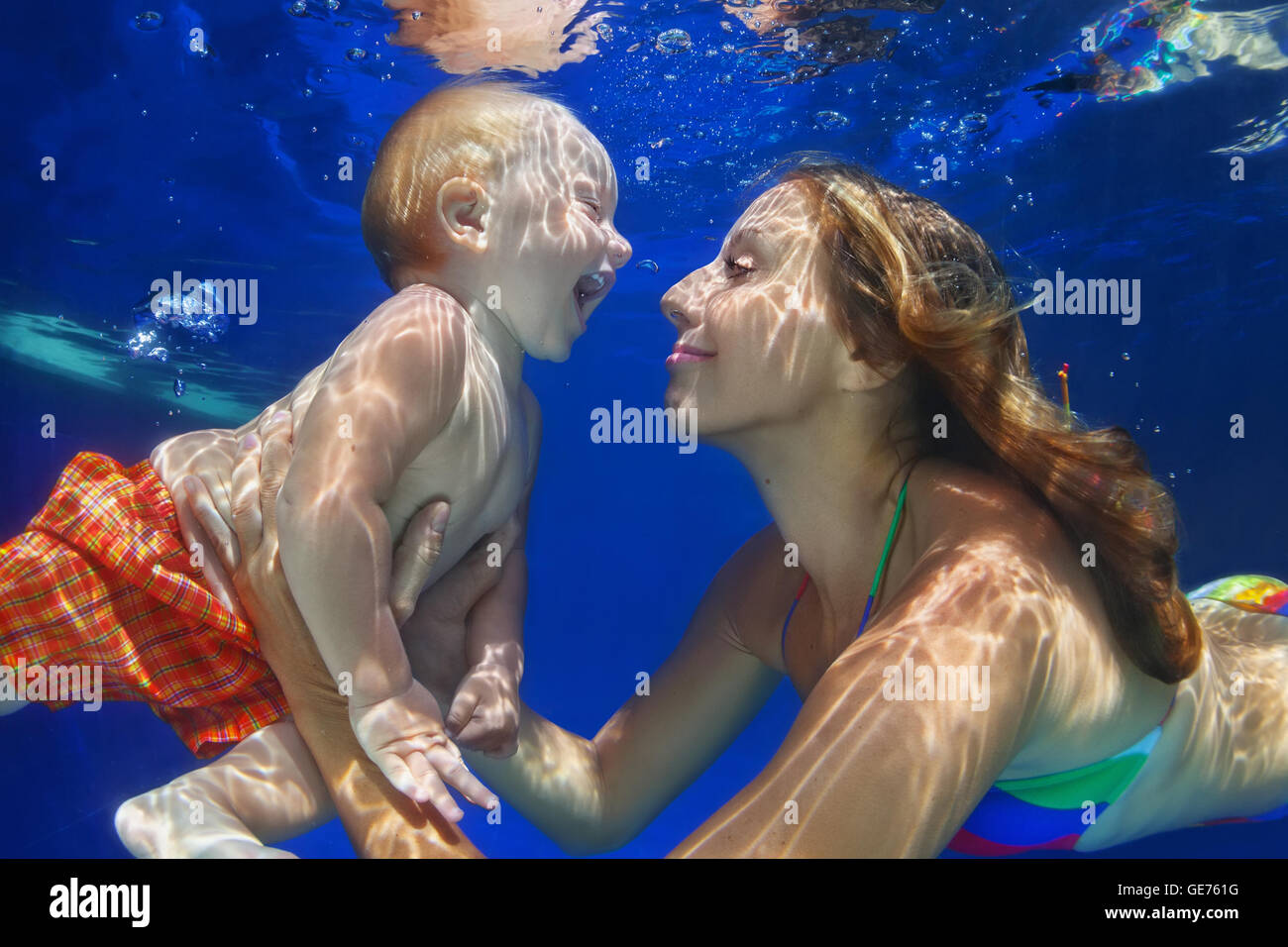 Glückliche Familie - Mutter, Baby Sohn lernen schwimmen und Tauchen unter Wasser mit Spaß im Schwimmbad. Kinder Wasser Sport Übungen. Stockfoto