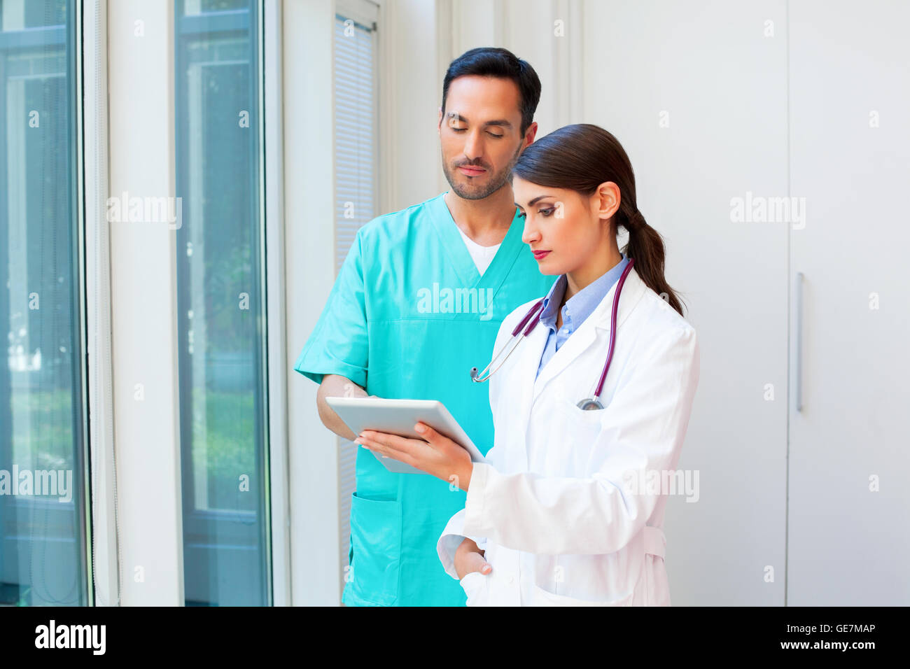Ein Foto des jungen Ärzteteam mit digital-Tablette. Mediziner sind in Uniformen. Sie stehen im Krankenhaus. Stockfoto