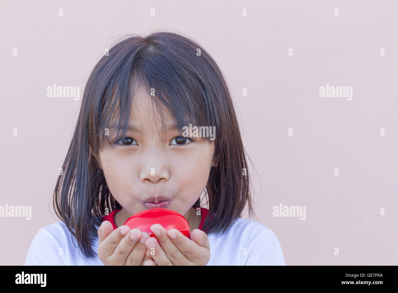 Kleine Asiatin zeigen großes rotes Herz. Konzept-Liebhaber und vorsichtig. Stockfoto
