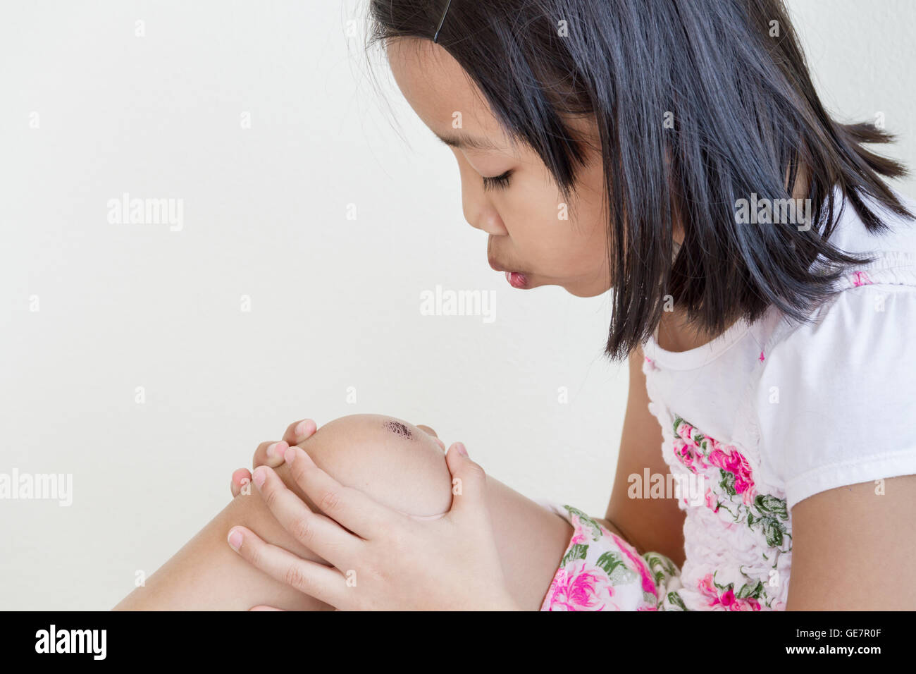 Kleine asiatische Kinder Mädchen bläst Wunde Stockfoto