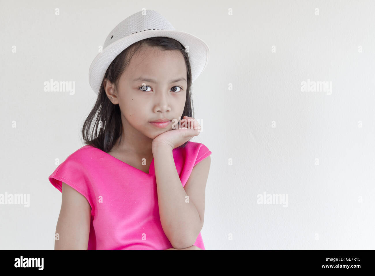 Entzückende glücklich asiatischen Kinder in einem rosa Kleid mit weißen Hut. Stockfoto
