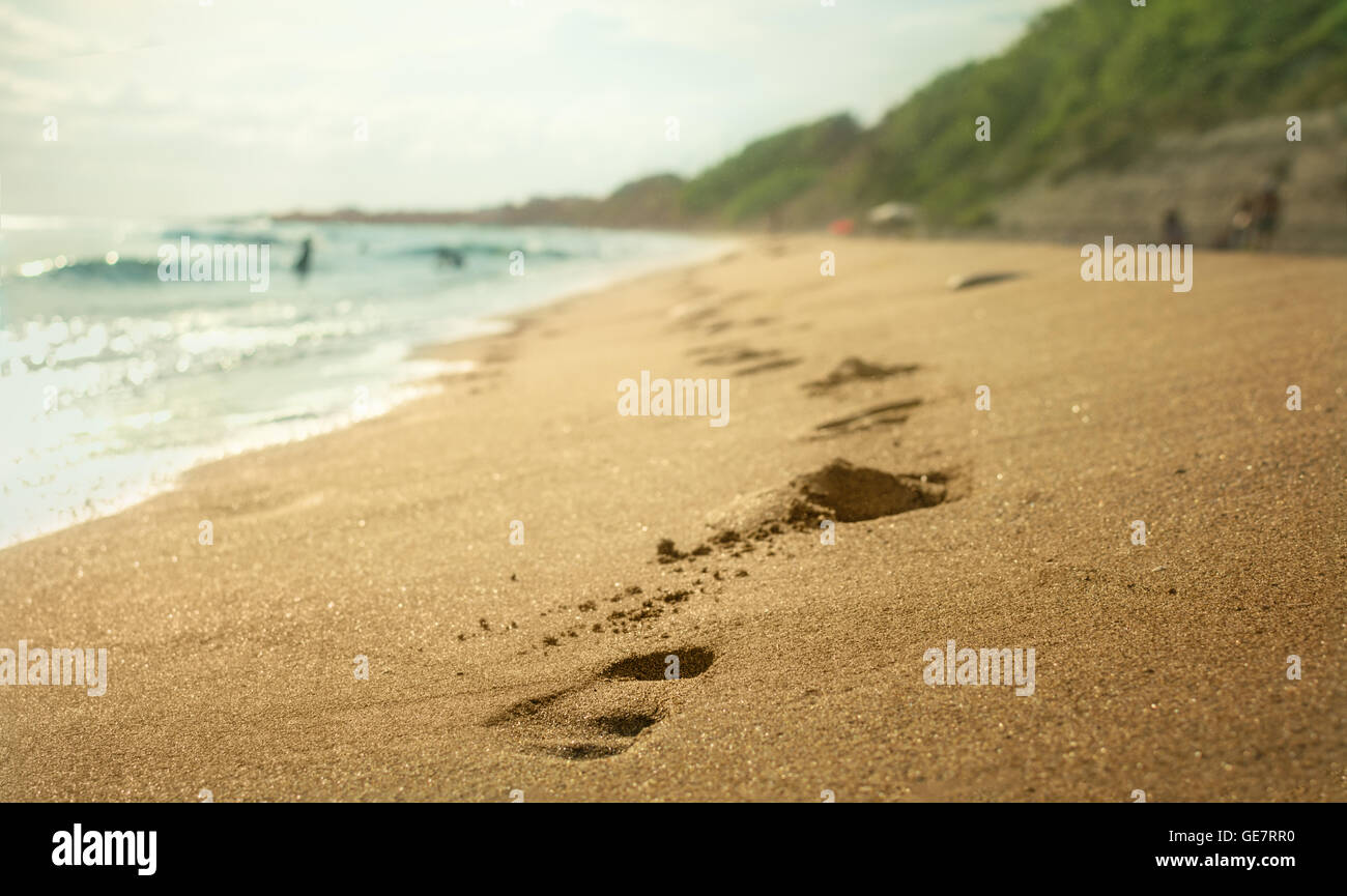 Fußspuren im Sand am Strand vom Meer an sonnigen Tag. Stockfoto