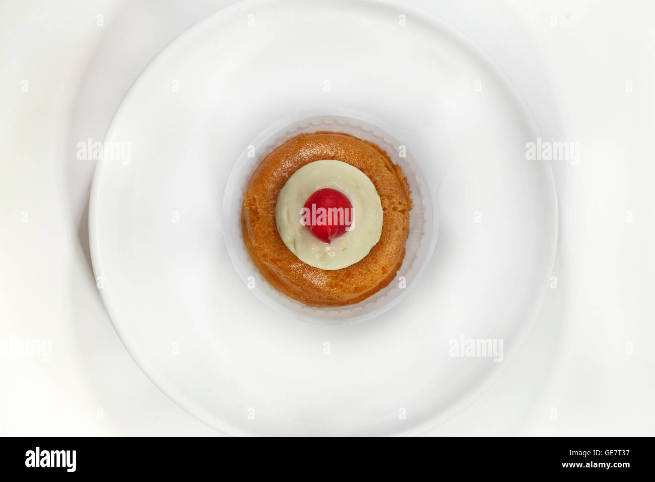 Französischer rum Kuchen und Kirsche auf einem Teller Stockfoto