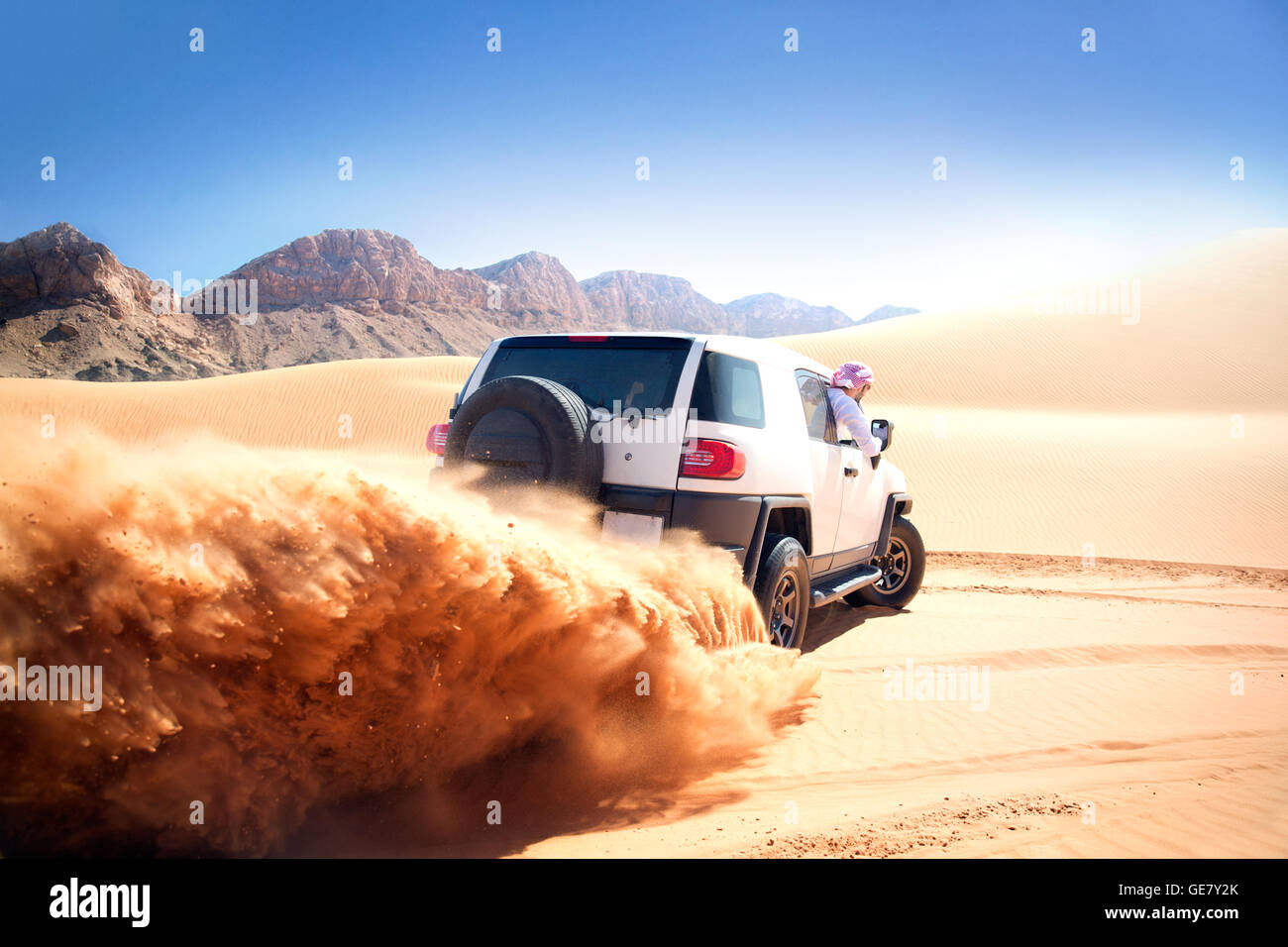 Arabische Mann FJ Cruiser auf Wüste treiben. Stockfoto