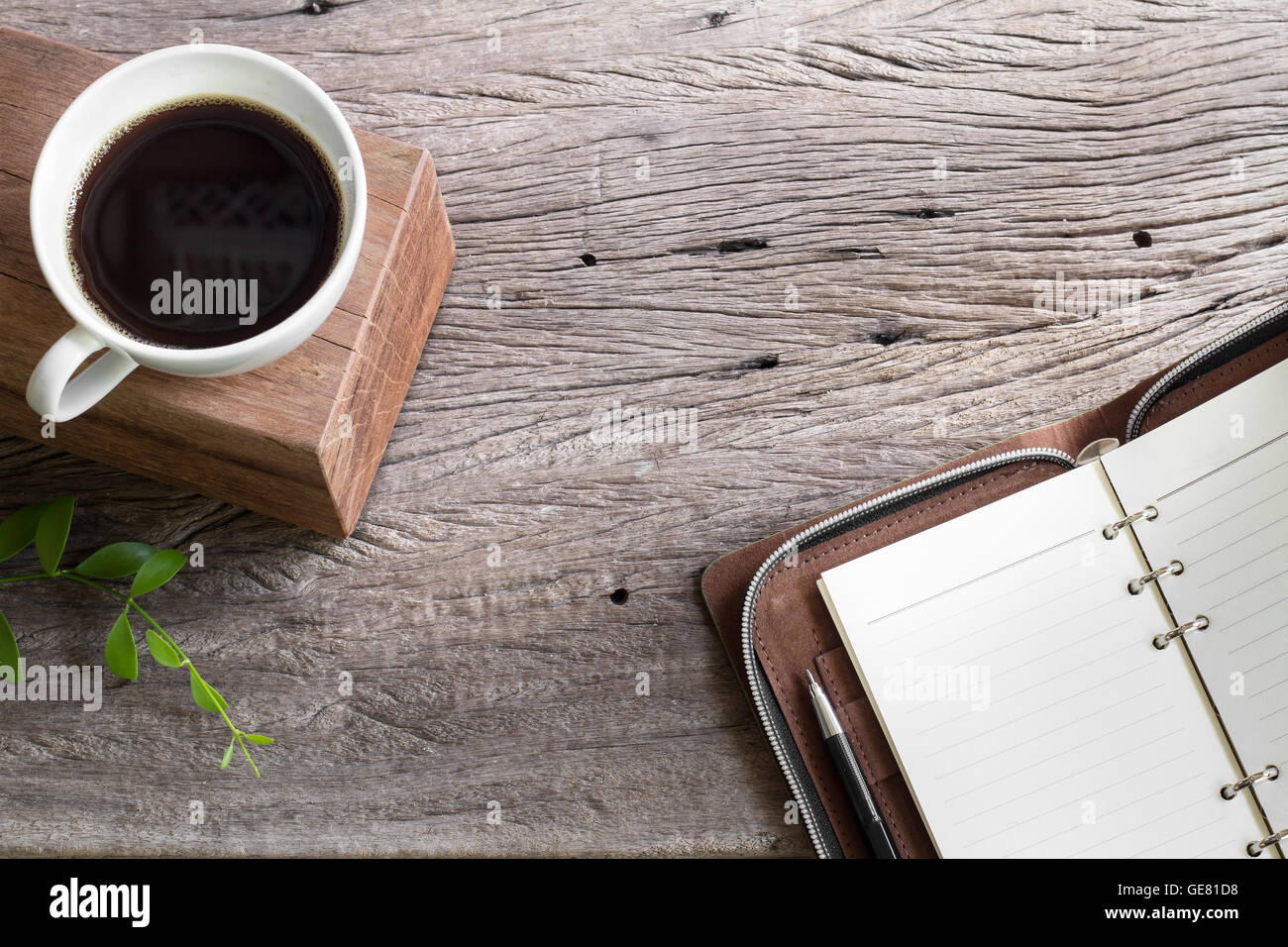 weiße Tasse Kaffee mit Notizbuch auf Holzplatte Tabelle isolierten hellen Hintergrund Stockfoto