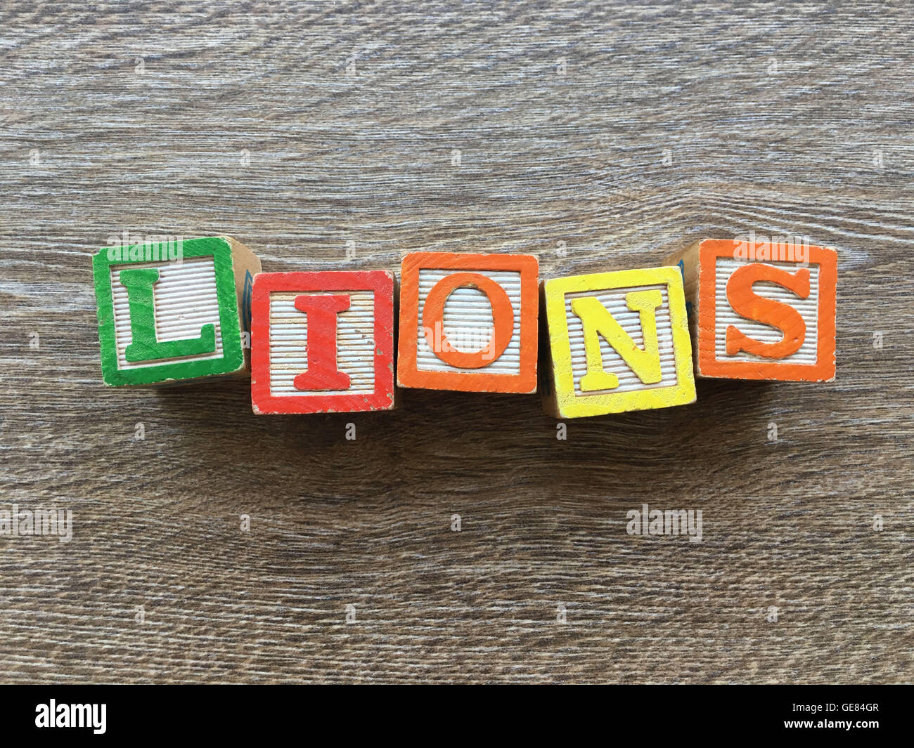 Holzblöcke oder hölzerne Würfel Spielzeug mit Alphabet Buchstaben darauf kombiniert zusammen, um das Wort Löwen Stockfoto