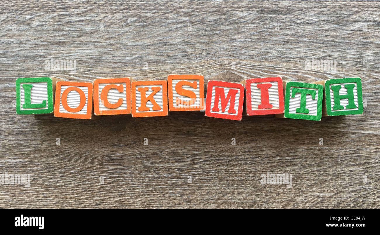 Holzblöcke oder hölzerne Würfel Spielzeug mit Alphabet Buchstaben darauf kombiniert zusammen, um das Wort Schlosser Stockfoto