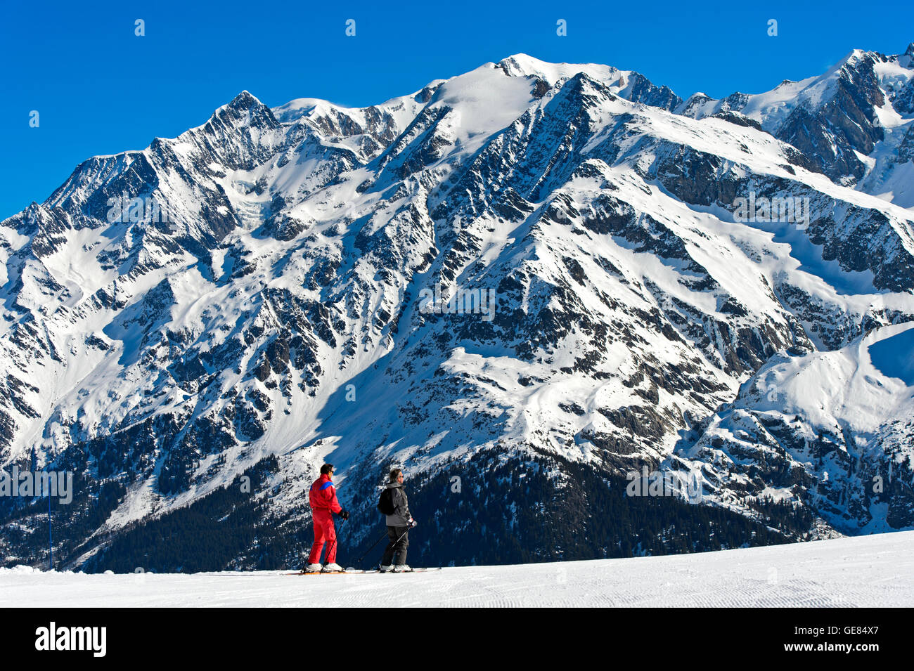 Skifahrer im Skigebiet Les Contamines-Montjoie gegen das Mont Blanc Massiv, Haute-Savoie, Frankreich Stockfoto