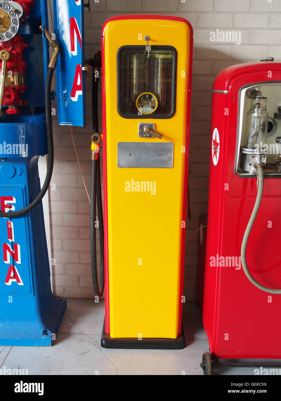 Dieses Bild zeigt eine alte Benzinpumpe, die die Entwicklung von Kraftstoffdosierern verdeutlicht. Design und Funktionalität spiegeln eine andere Ära der Automobilgeschichte wider und repräsentieren eine nostalgische Sicht auf Tankstellen des frühen 20. Jahrhunderts. Stockfoto