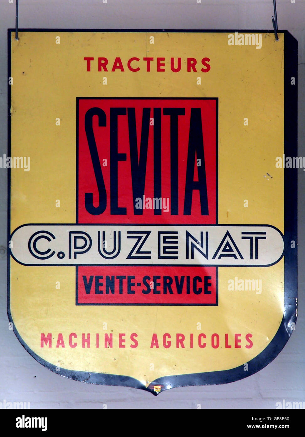 Diese Vintage-Werbetafel für Sevita Tractors zeigt ein historisches Stück Landmaschinen-Marketing. Das alte Schild spiegelt frühere Werbepraktiken wider und dient als Einblick in die Geschichte der Landwirtschaft und unterstreicht die Rolle der Traktoren bei der Modernisierung der Landwirtschaft. Stockfoto