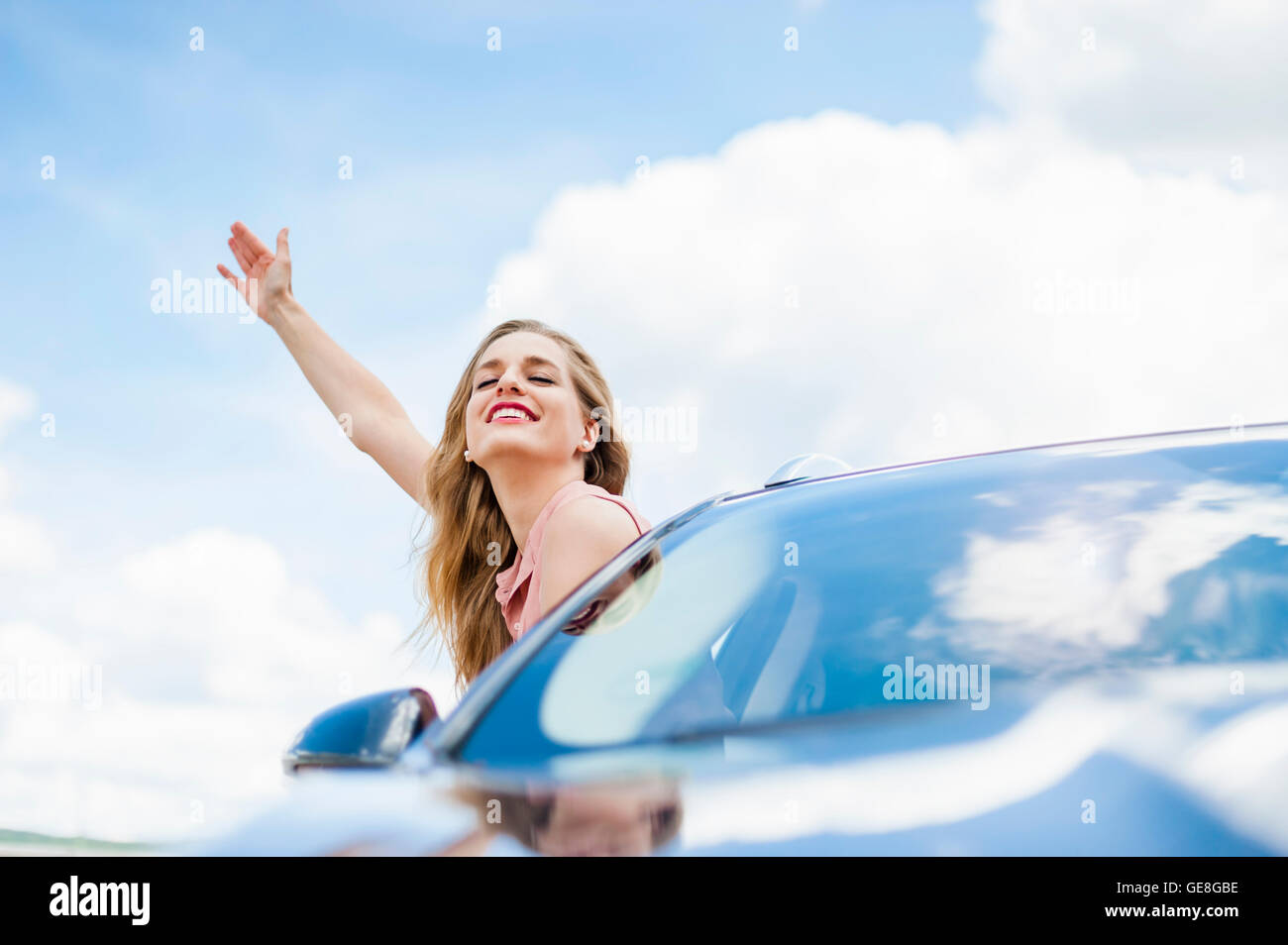 Porträt der lächelnde junge Frau mit Augen geschlossen schiefen aus Autofenster Stockfoto