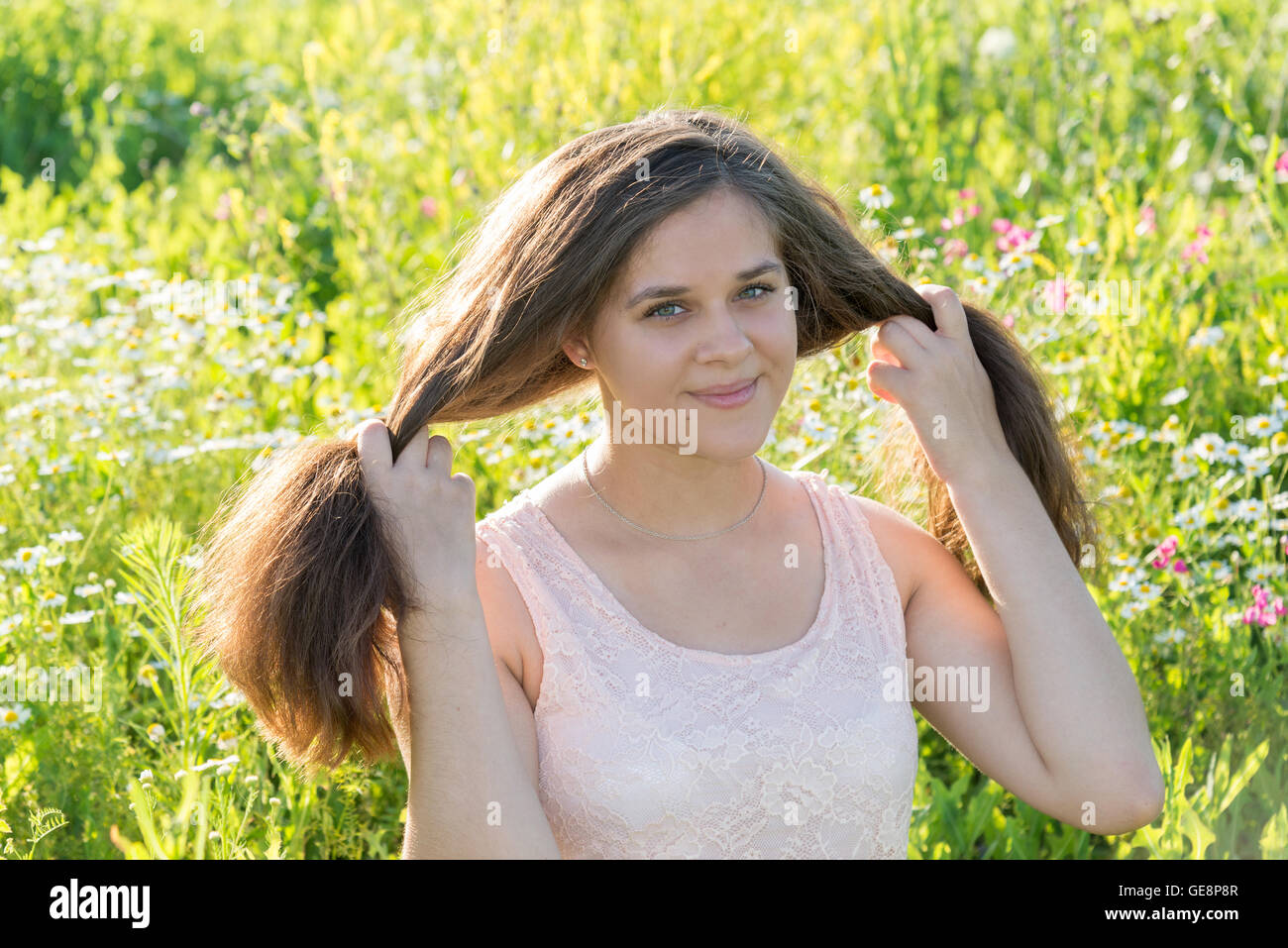 Mädchen mit langen Haaren auf Blumenwiese Stockfoto