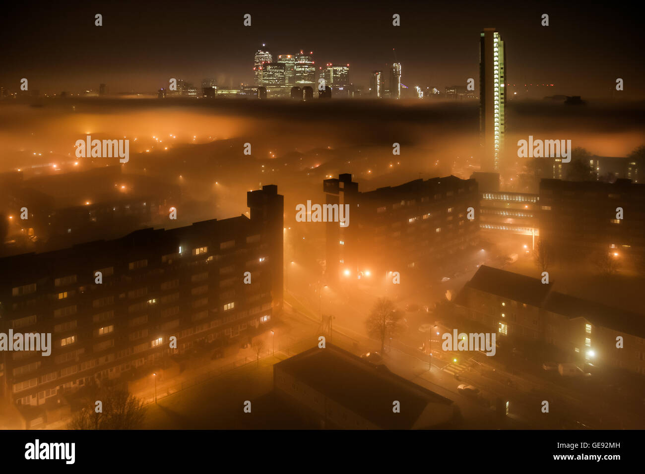 Dichten Decke Nebel deckt eine Süd-Ost-London Wohnsiedlung einschließlich der Canary Wharf Business Park Gebäude, UK. Stockfoto