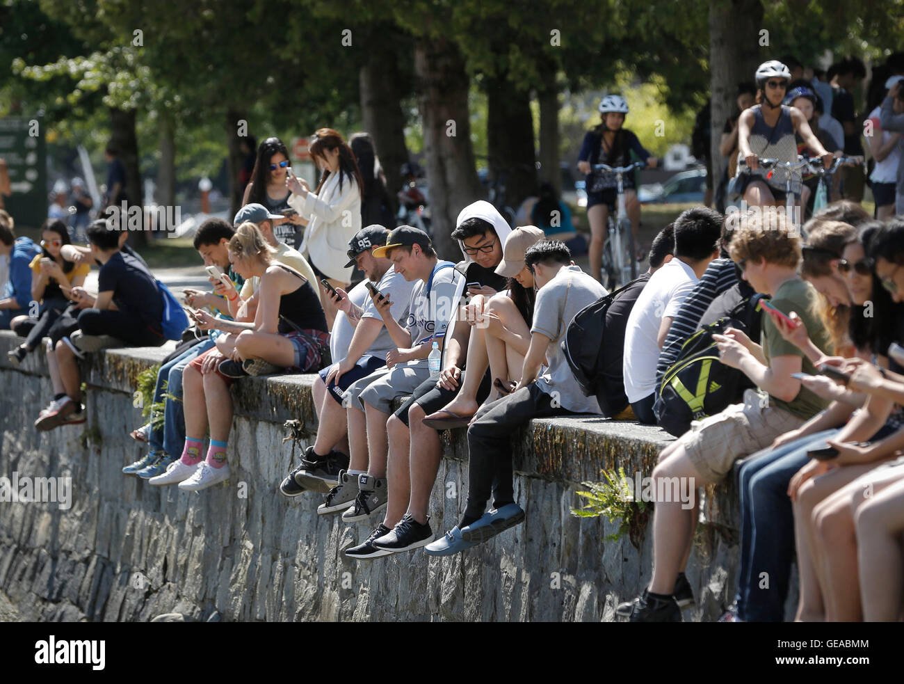 Vancouver, Kanada. 23. Juli 2016. Menschen spielen "Pokemon Go" während einer Versammlung im Stanley Park in Vancouver, Kanada, 23. Juli 2016. Mehr als 1.000 Fans ging nach draußen auf die Jagd nach Pokemon beitreten. Augmented-Reality-Spiel "Pokemon Go" ist ein Smartphone-Verjüngung der beliebten japanischen Videospiel-Serie Pokémon, das bis in die 1990er Jahre datiert. Im Spiel sind Spieler verpflichtet, erkunden ihre Umgebung um Kreaturen finden, trainiere sie und nutzen sie, um gegen andere Spieler kämpfen. Bildnachweis: Liang Sen/Xinhua/Alamy Live-Nachrichten Stockfoto