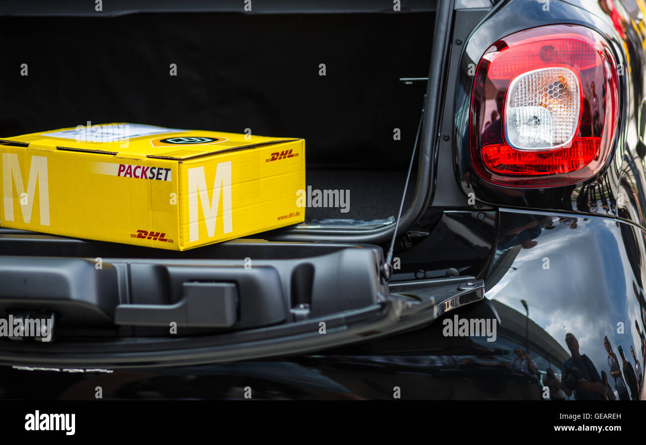Böblingen, Deutschland. 25. Juli 2016. Eine DHL-Paket liegt in den Kofferraum eines Smart Autos in Böblingen, 25. Juli 2016. Intelligente und DHL planen Stamm Lieferung. Paket-Träger werden in der Lage, Pakete an den Stämmen des Kleinwagens mit Key-Less-Technologie zu liefern. Foto: Christoph Schmidt/Dpa/Alamy Live News Stockfoto