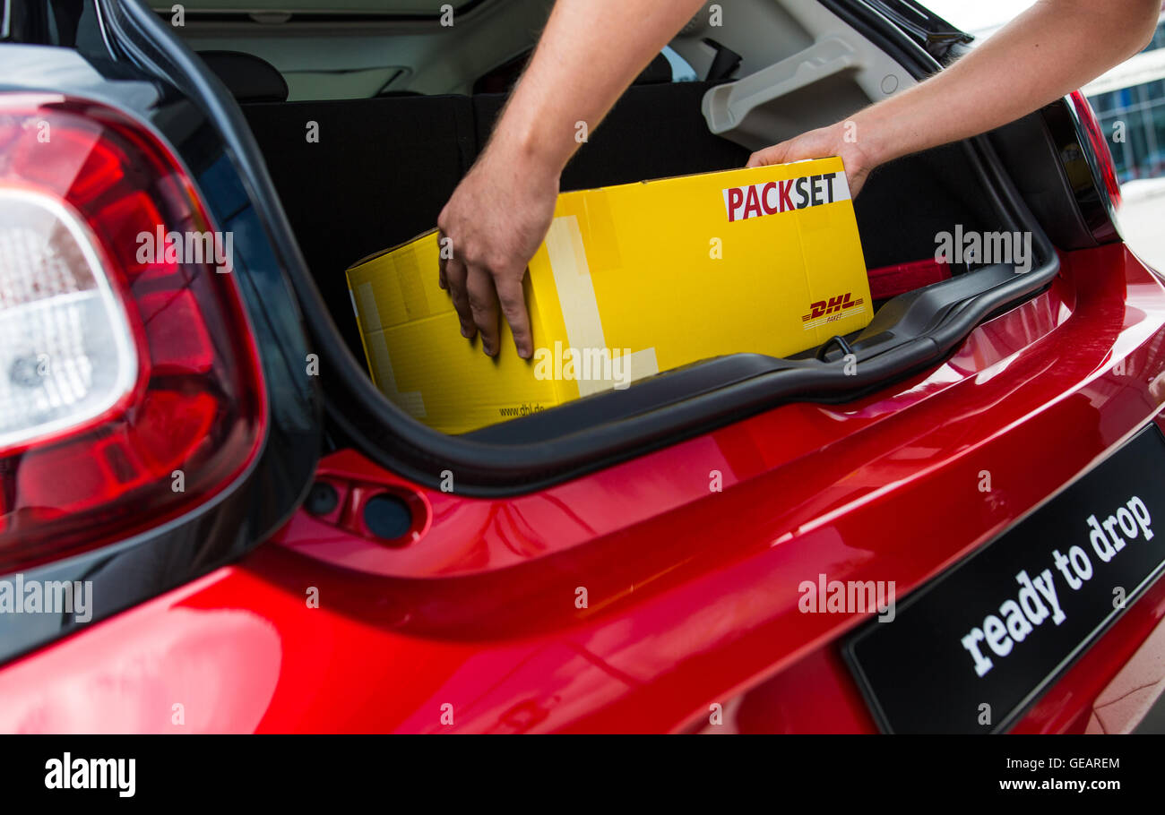 Böblingen, Deutschland. 25. Juli 2016. Ein DHL-Bote stellt eine Paket in den Kofferraum eines Smart Autos in Böblingen, 25. Juli 2016. Intelligente und DHL planen Stamm Lieferung. Paket-Träger werden in der Lage, Pakete an den Stämmen des Kleinwagens mit Key-Less-Technologie zu liefern. Foto: Christoph Schmidt/Dpa/Alamy Live News Stockfoto