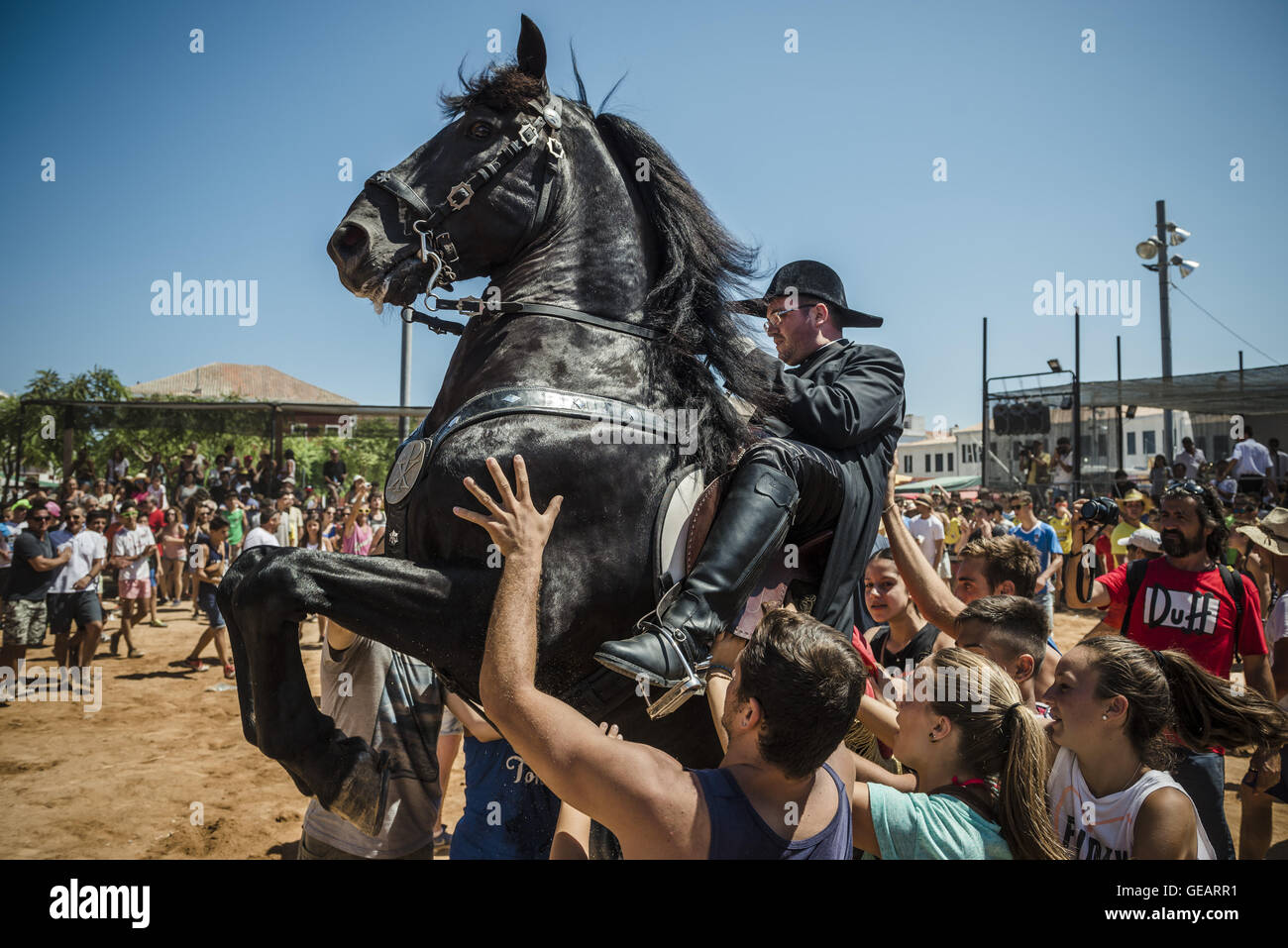 Es Castell, Balearen, Spanien. 25. Juli 2016. Ein "Caixer" (Reiter) bäumt sich auf seinem Pferd, umgeben von einer jubelnden Menge während der 2. "Jaleo" des traditionellen "Sant Jaume" (Jakobsweg) Festival in Es Castell, der Stadt Gönner Heiliges Fiesta Credit: Matthias Oesterle/ZUMA Draht/Alamy Live News Stockfoto