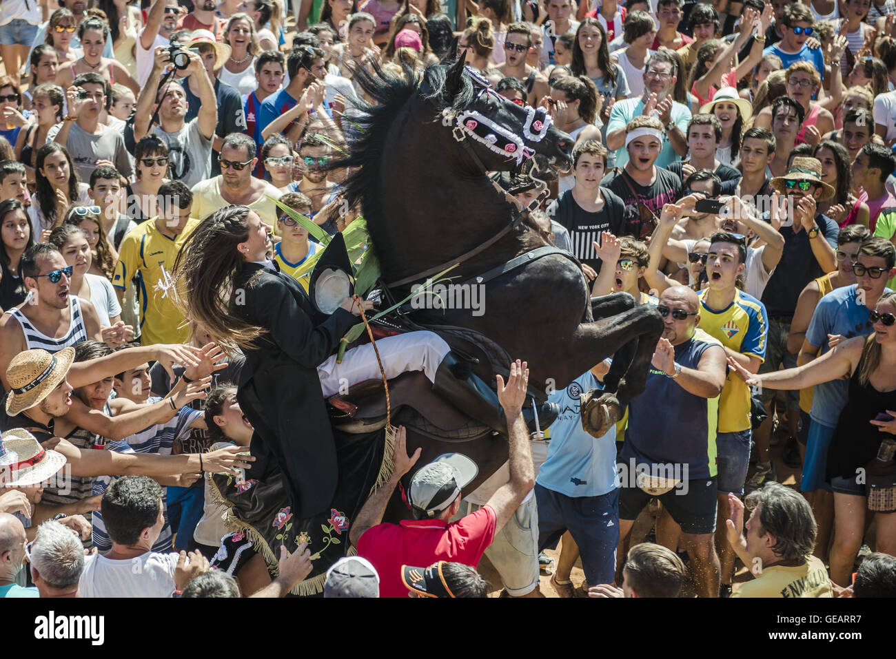 Es Castell, Balearen, Spanien. 25. Juli 2016. Ein "Caixer" (Reiter) bäumt sich auf seinem Pferd, umgeben von einer jubelnden Menge während der 2. "Jaleo" des traditionellen "Sant Jaume" (Jakobsweg) Festival in Es Castell, der Stadt Gönner Heiliges Fiesta Credit: Matthias Oesterle/ZUMA Draht/Alamy Live News Stockfoto