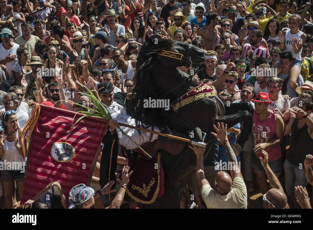 Es Castell, Balearen, Spanien. 25. Juli 2016. Ein "Caixer" (Reiter) bäumt sich auf seinem Pferd, umgeben von einer jubelnden Menge während der 2. "Jaleo" des traditionellen "Sant Jaume" (Jakobsweg) Festival in Es Castell, der Stadt Gönner Heiliges Fiesta Credit: Matthias Oesterle/ZUMA Draht/Alamy Live News Stockfoto