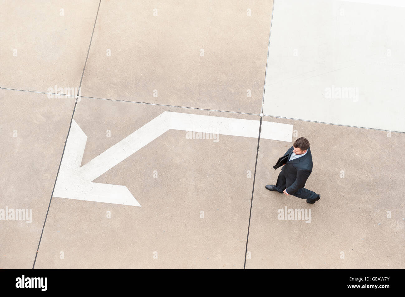 Geschäftsmann zu Fuß auf mit großen Pfeil zu bereiten Stockfoto