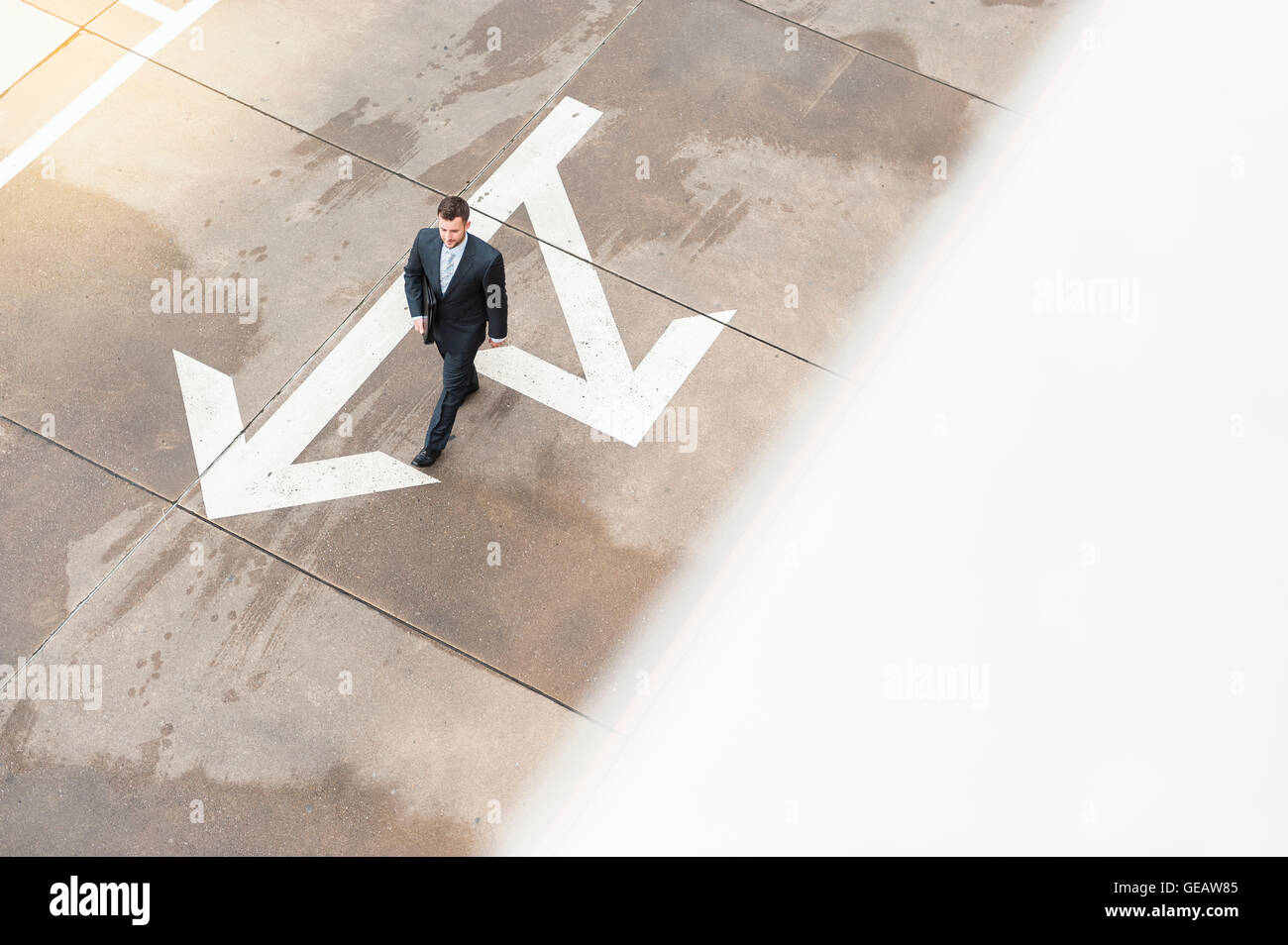 Geschäftsmann zu Fuß auf mit großen Pfeil zu bereiten Stockfoto
