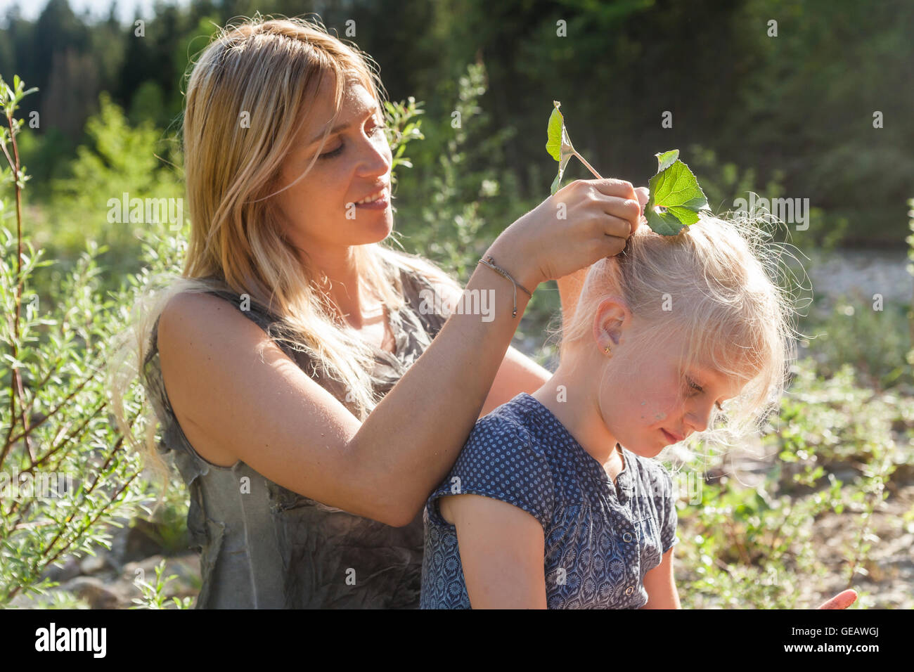 Mutter fixieren lässt ihre Tochter Haar Stockfoto