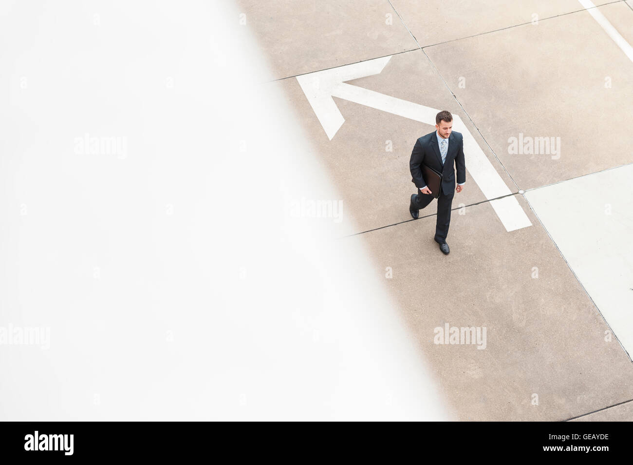 Geschäftsmann zu Fuß auf mit großen Pfeil zu bereiten Stockfoto