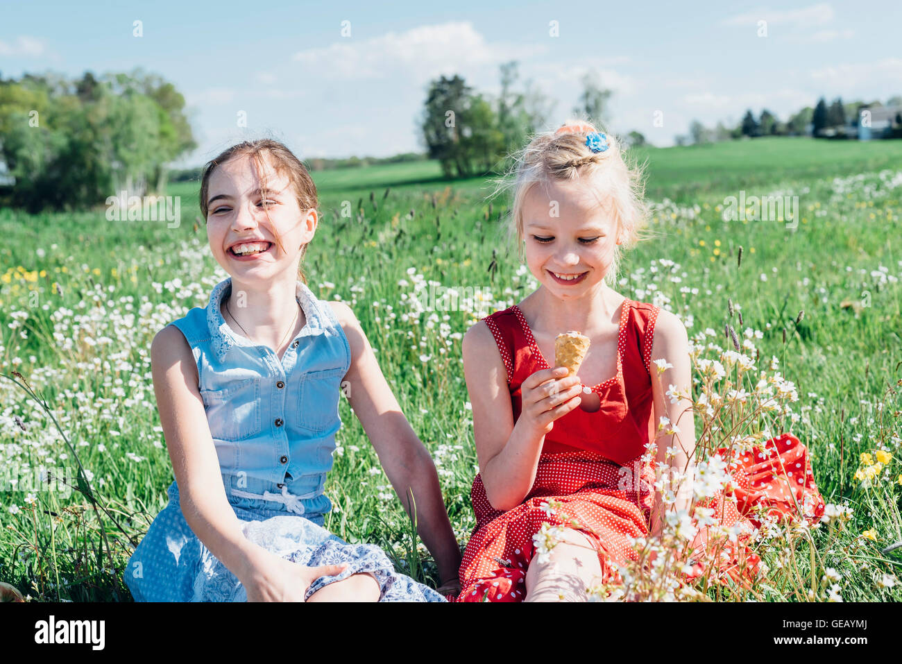 Zwei Mädchen auf Wiese mit Eiscreme-Kegel Stockfoto