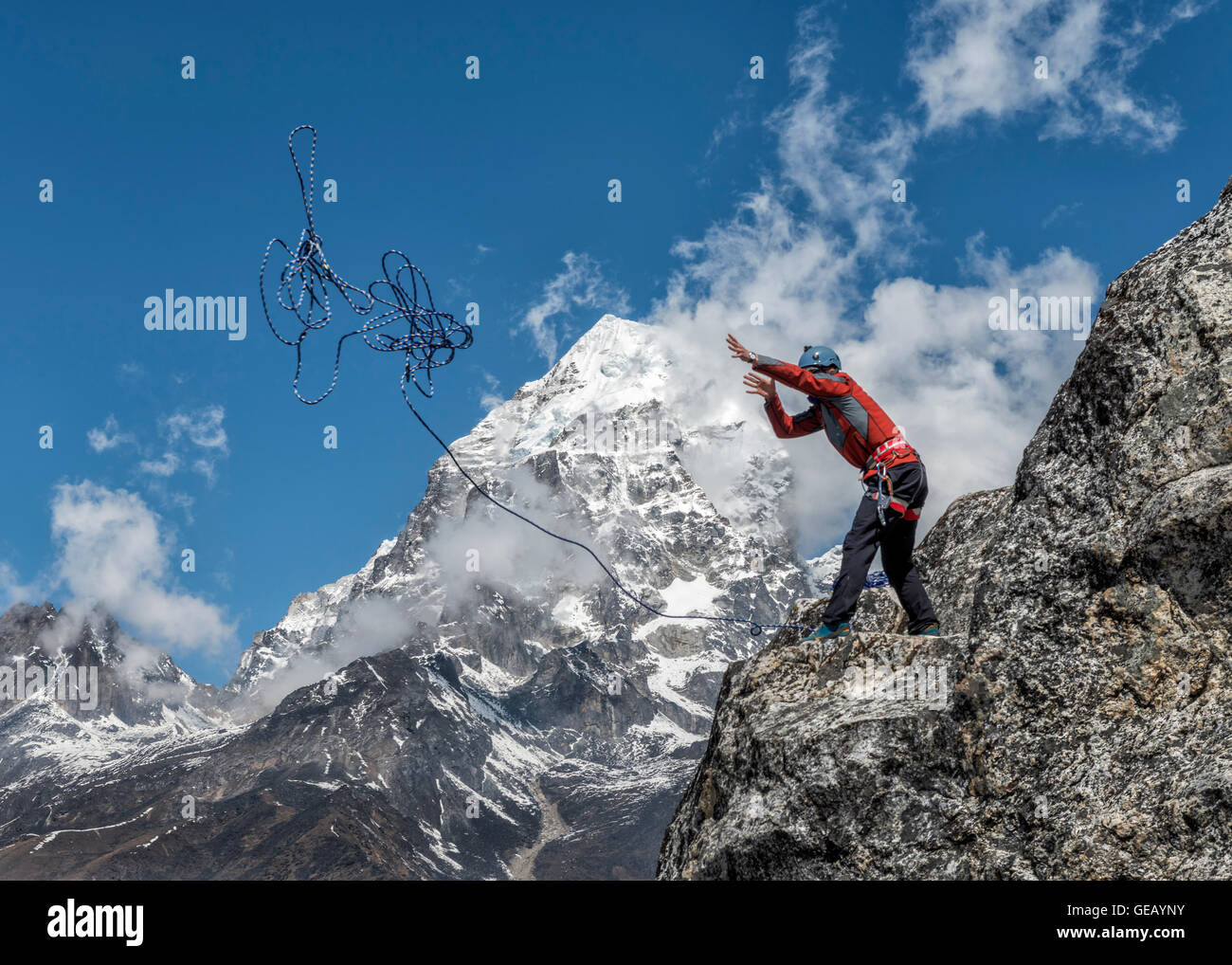 Nepal, Himalaya, Solo Khumbu, Ama Dablam, Mann steht auf Felsen werfen Seil Stockfoto