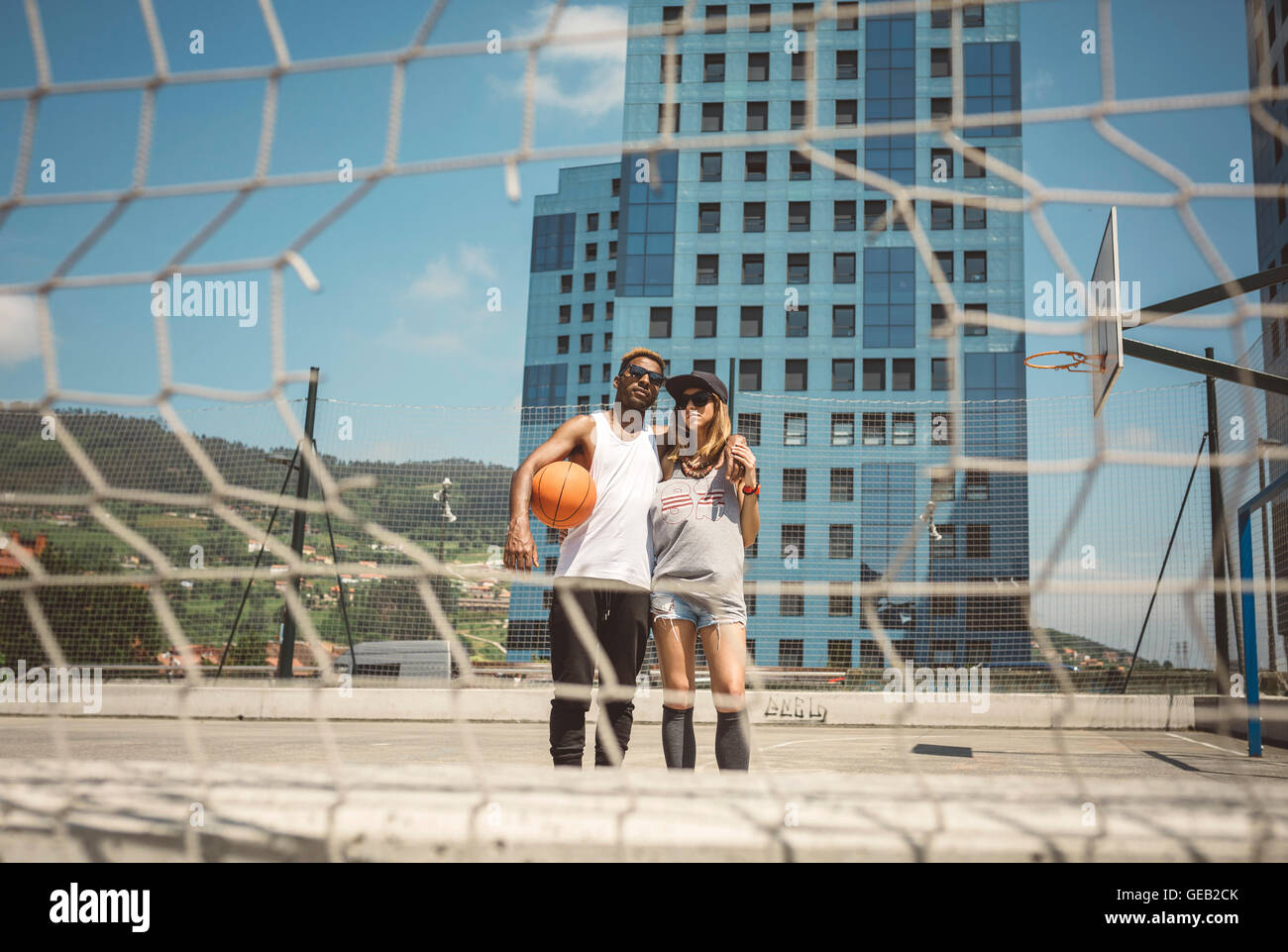 Junges Paar auf Basketballfeld, Blick in die Kamera Stockfoto