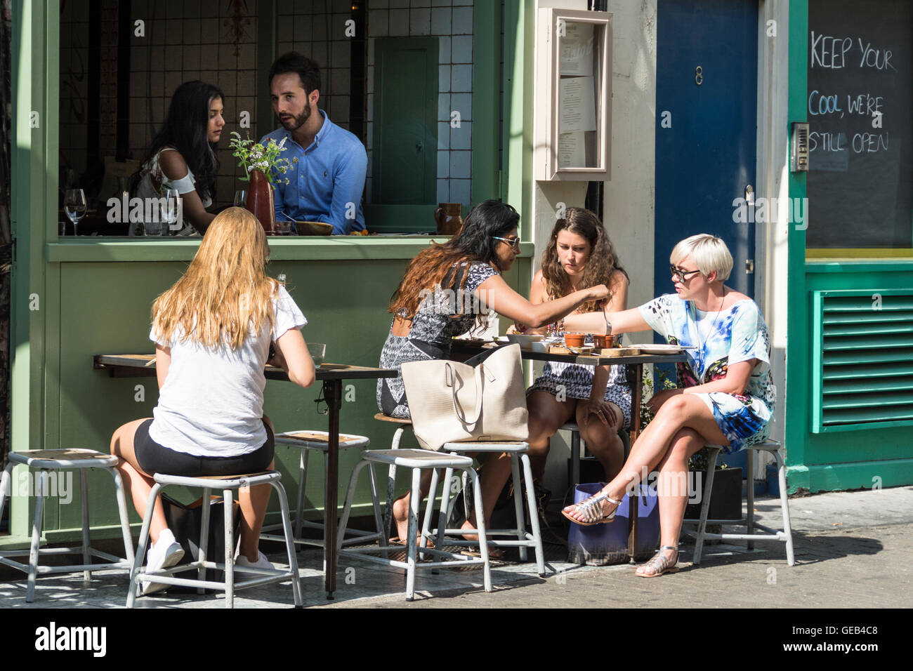 Eine Gruppe von Menschen Essen und Geselligkeit in einem von Londons West End Straßen Stockfoto