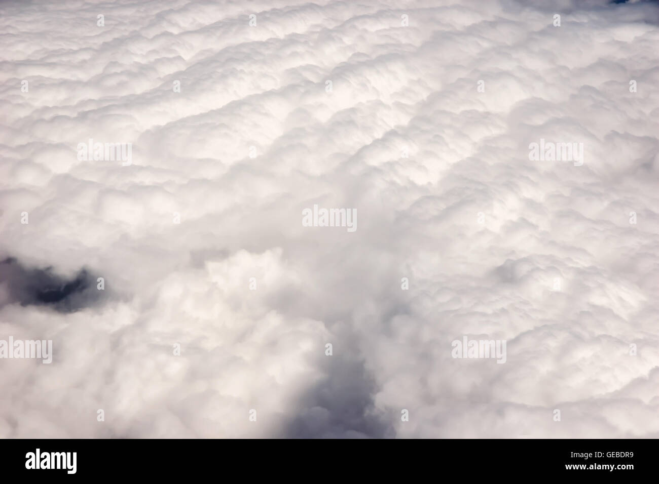 Blick aus dem Flugzeugfenster auf flauschige Cumulus-Wolken Stockfoto
