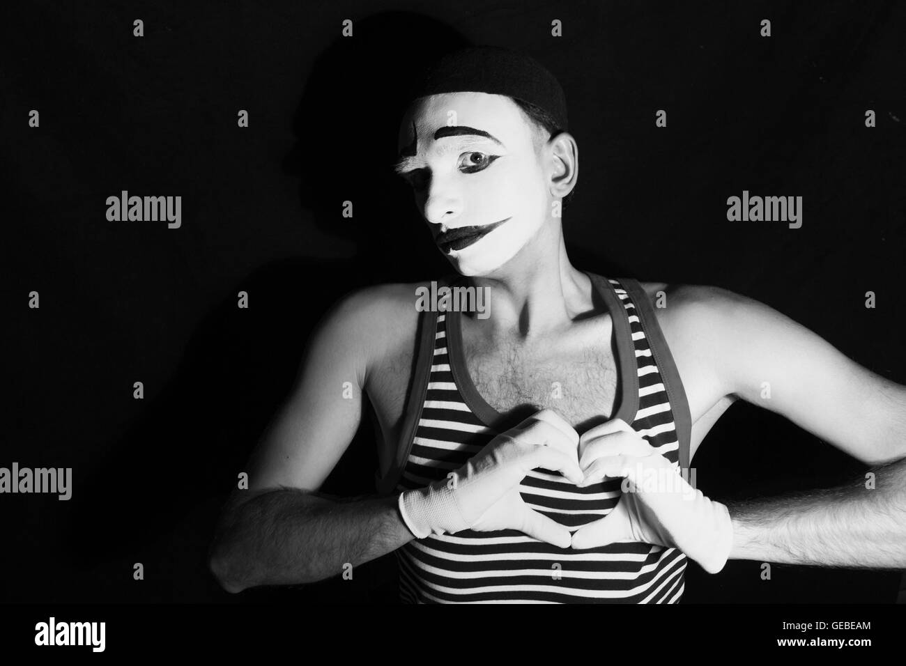 Porträt von traurig Mime mit Herzen auf schwarzem Hintergrund Stockfoto