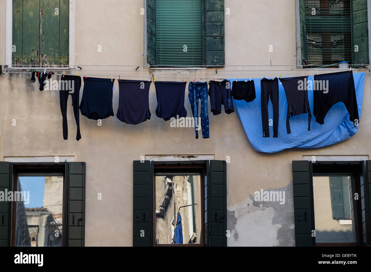Schwarze und blaue Wäsche hängen auf eine Kleidung Linie und Reflexionen-Venedig-Italien Stockfoto
