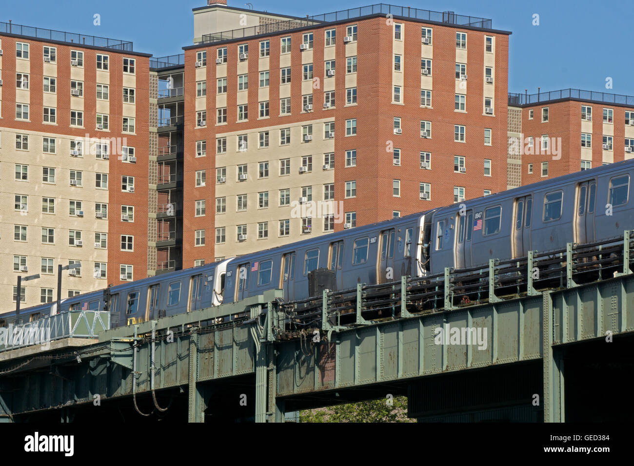 Die Hochbahn Q läuft sehr nah an einer Anlage mit high-Rise Wohnungen in Coney Island, Brooklyn, New York Stockfoto